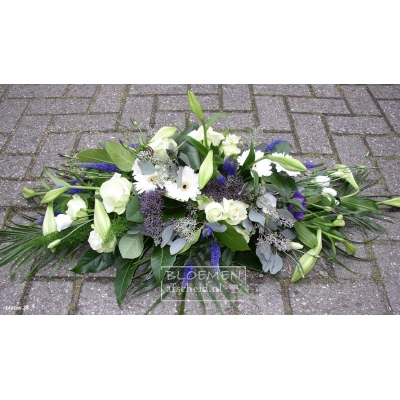 Langwerpig wit rouwarrangement met enkele blauwe bloemen