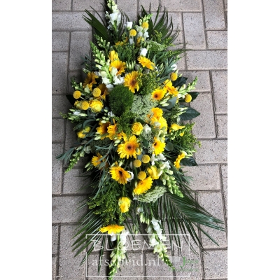 Langwerpig rouwarrangement van gele en witte bloemen