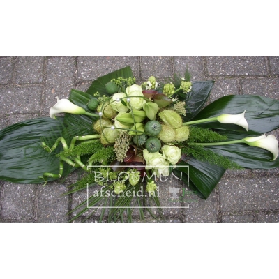 Compact opgestoken rouwarrangement van o.a. calla's in groen en wit