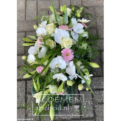 Langwerpig rouwarrangement van orchideeën, rozen en lelies